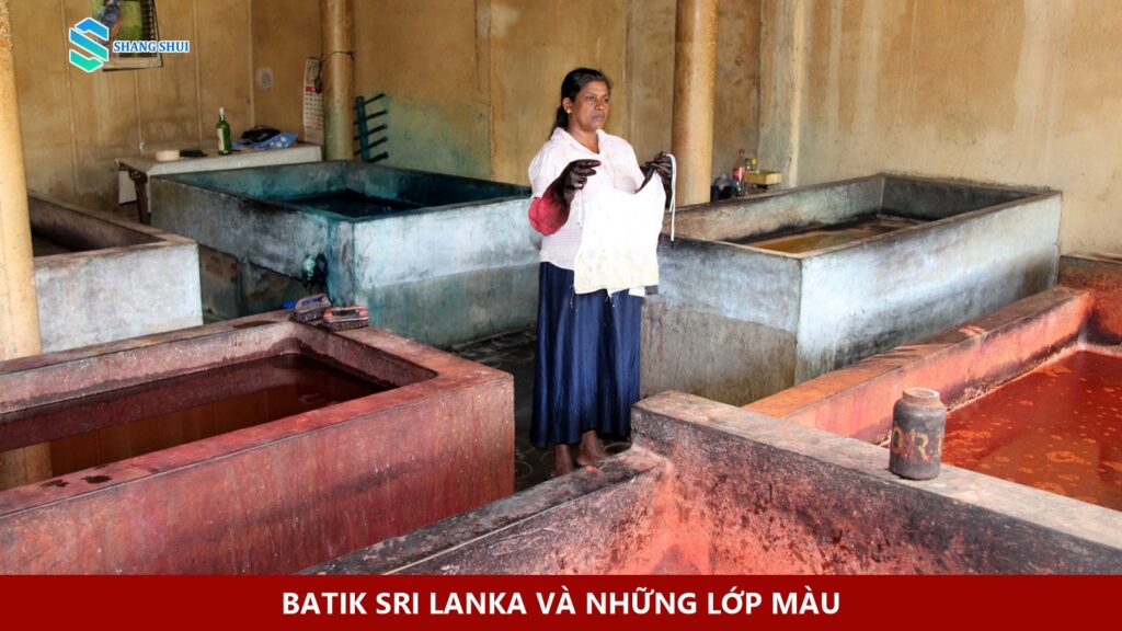 Người thợ cầm vải giữa các bể nhuộm batik tại Kandy.