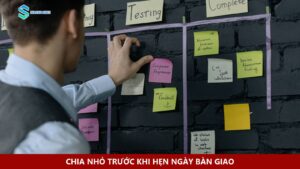 Một người sắp xếp giấy ghi chú trên bảng công việc.