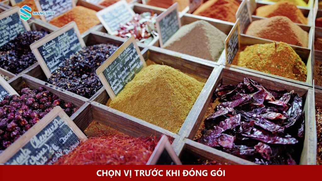 Nhiều khay gia vị khô và bột gia vị bày tại một quầy hàng.