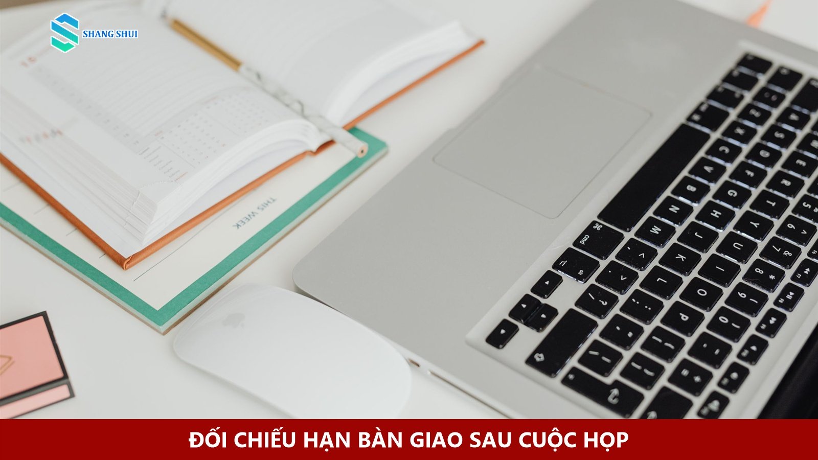 Sổ lịch mở bên laptop trên bàn làm việc