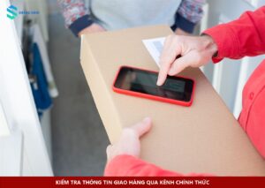 Người giao hàng cầm điện thoại trên kiện hàng, minh họa việc đối chiếu thông tin giao nhận