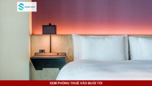 Căn phòng trọ với ánh đèn ấm áp và cửa sổ nhìn ra ban công ban đêm.